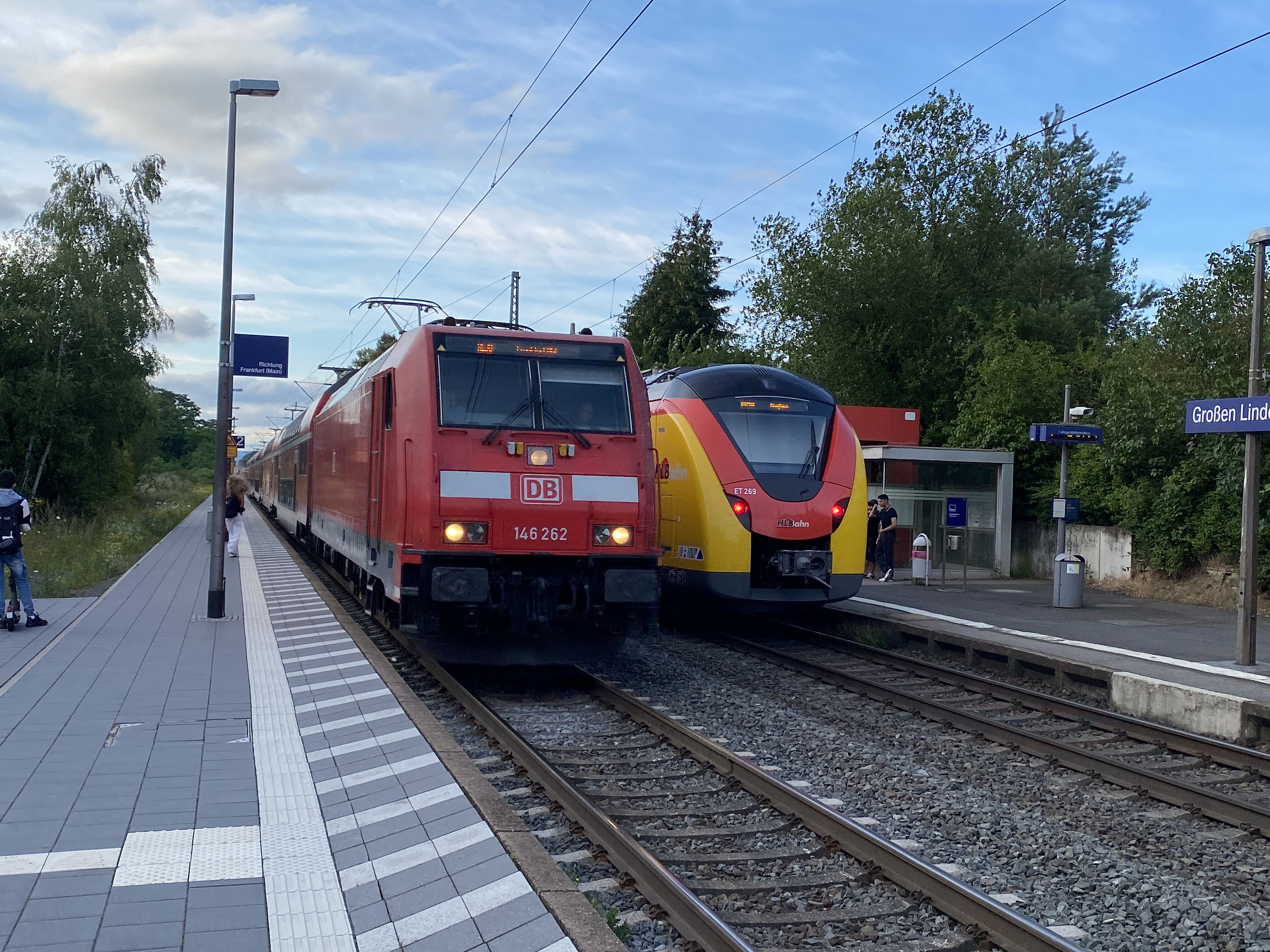 Ein Zug der Deutschen Bahn und ein Zug der hessischen Landesbahn begegnen sich im Bahnhof Großen-Linden